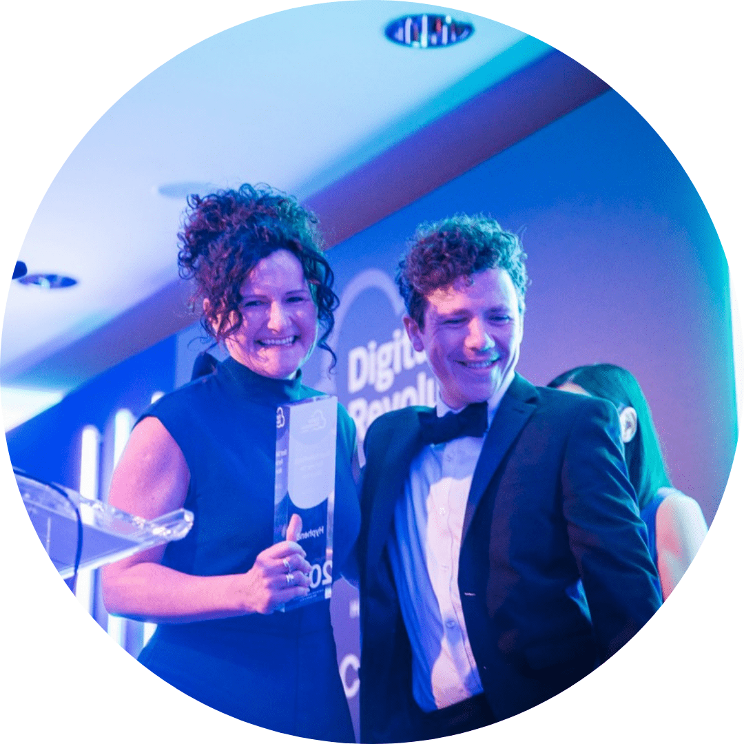 Man and Women smiling leave stage with an award at the Digital Revolution awards.