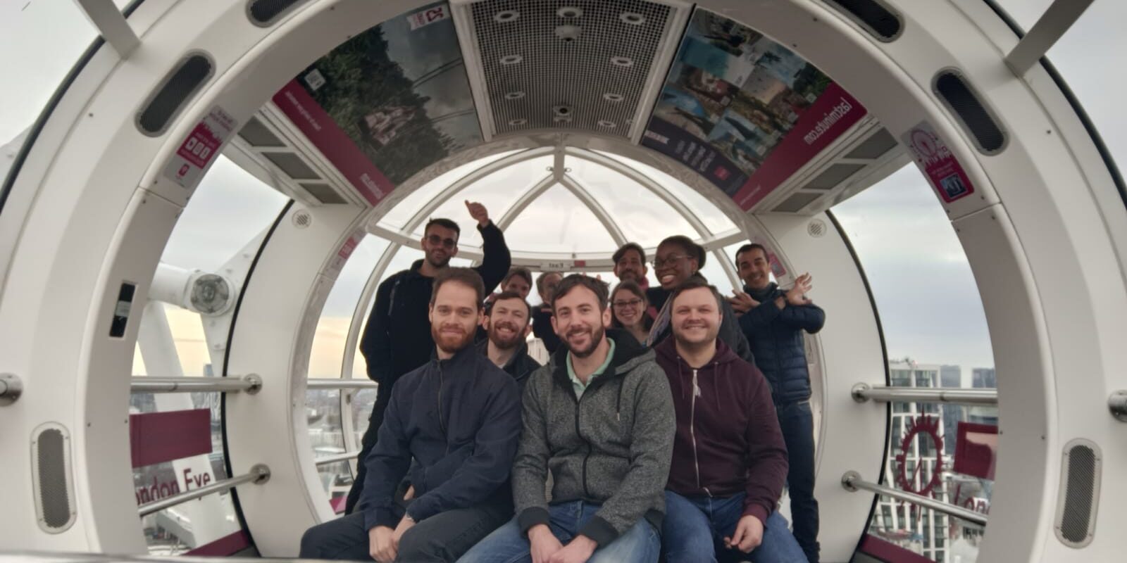 A group of people look at the camera inside the London Eye
